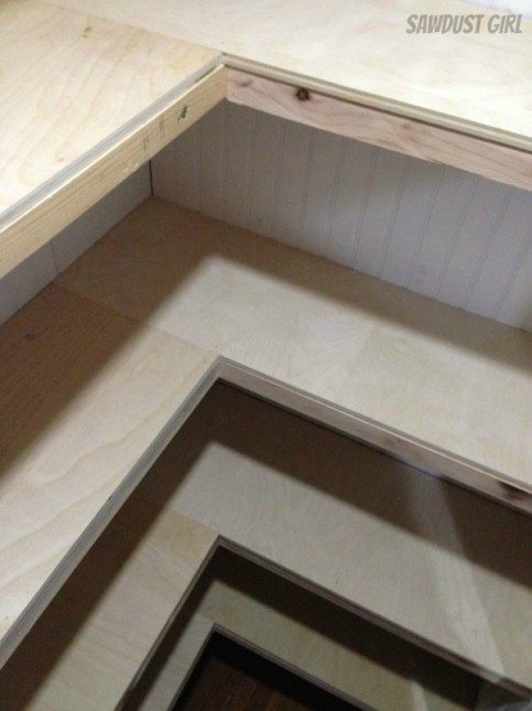 In-progress view of U-shaped shelf installation in a white-painted hallway closet.
