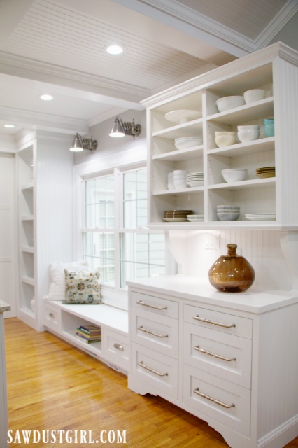 White cabinets in kitchen with window seat and China hutch