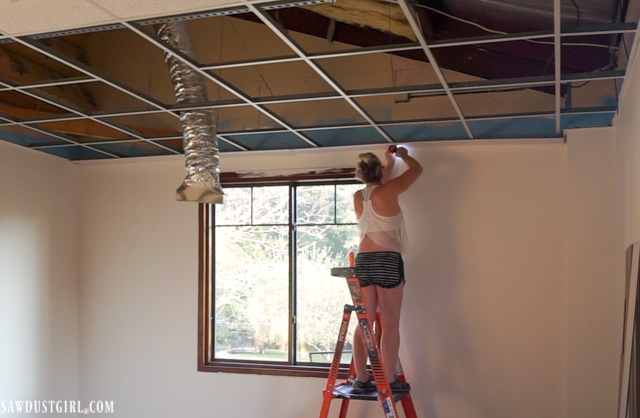 Installing surface mount planks on a drop ceiling grid.